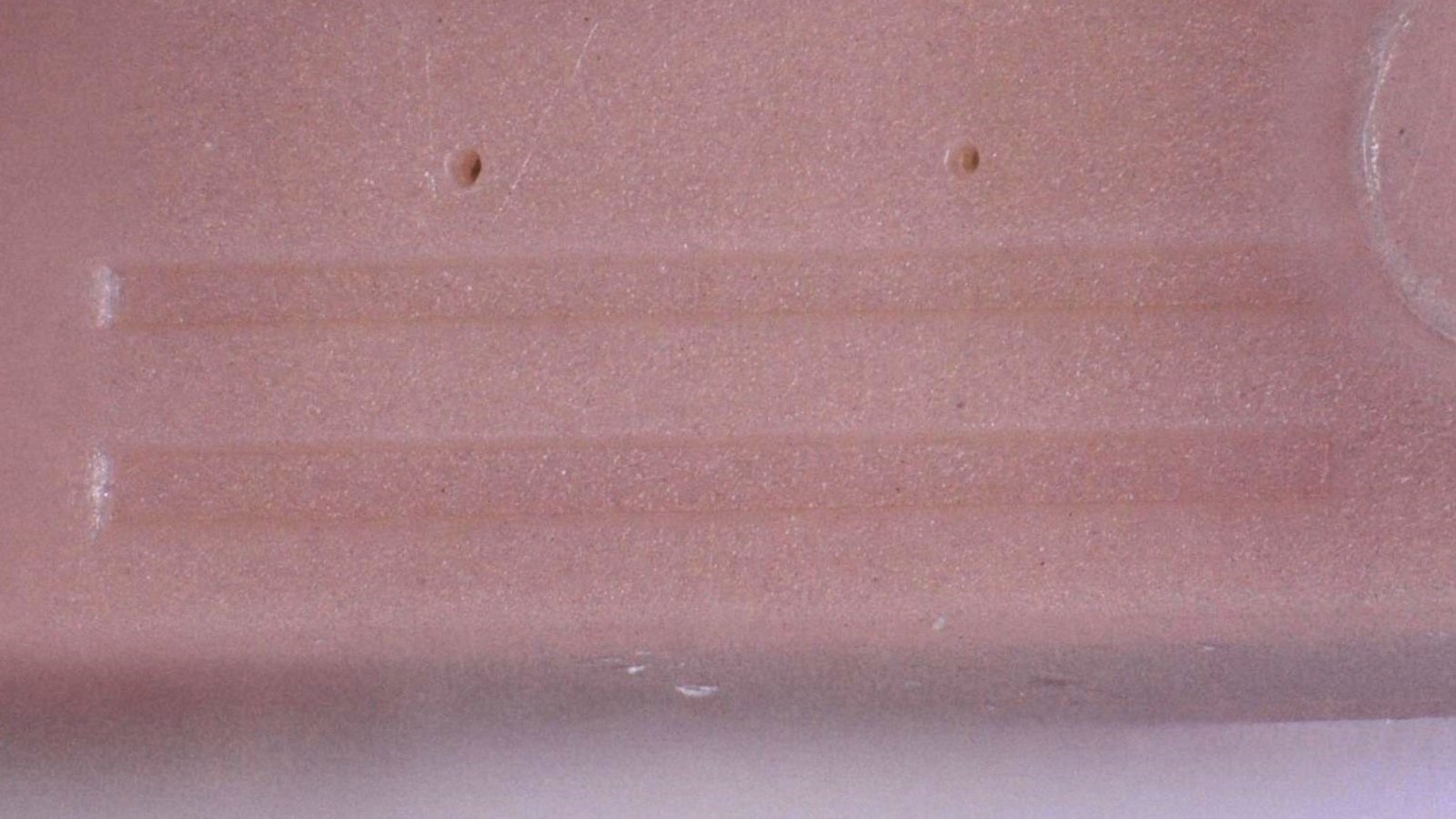 Close-up of a micro-molded plastic part demonstrating Cicor's precision plastics capabilities.