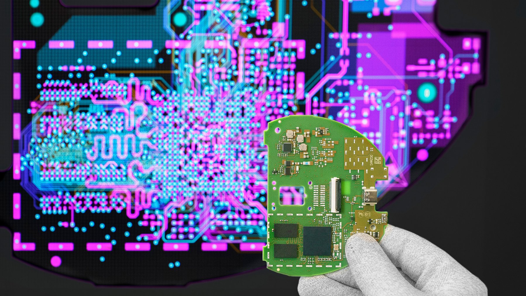Cicor engineer holding a PCB in front of a screen displaying the PCB design