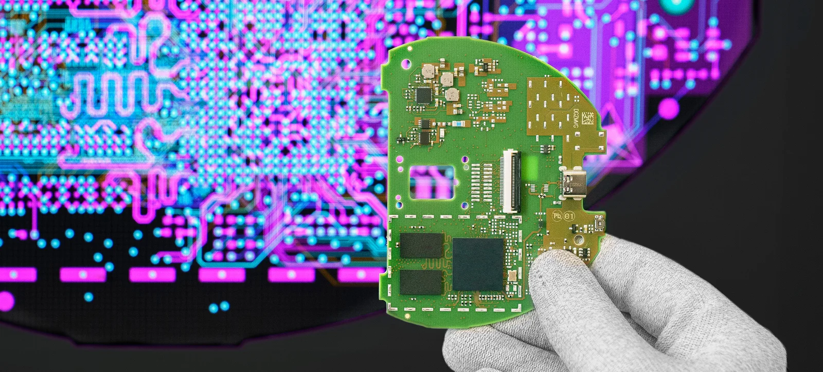 Cicor engineer holding a PCB in front of a screen displaying the PCB design