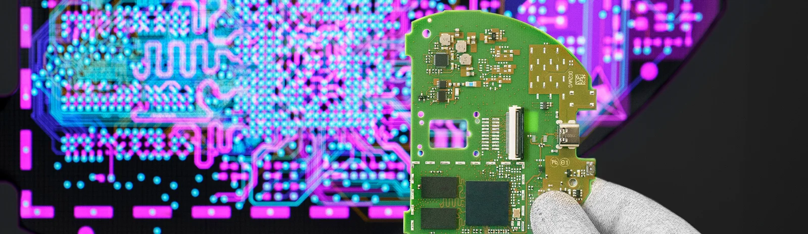 Cicor engineer holding a PCB in front of a screen displaying the PCB design