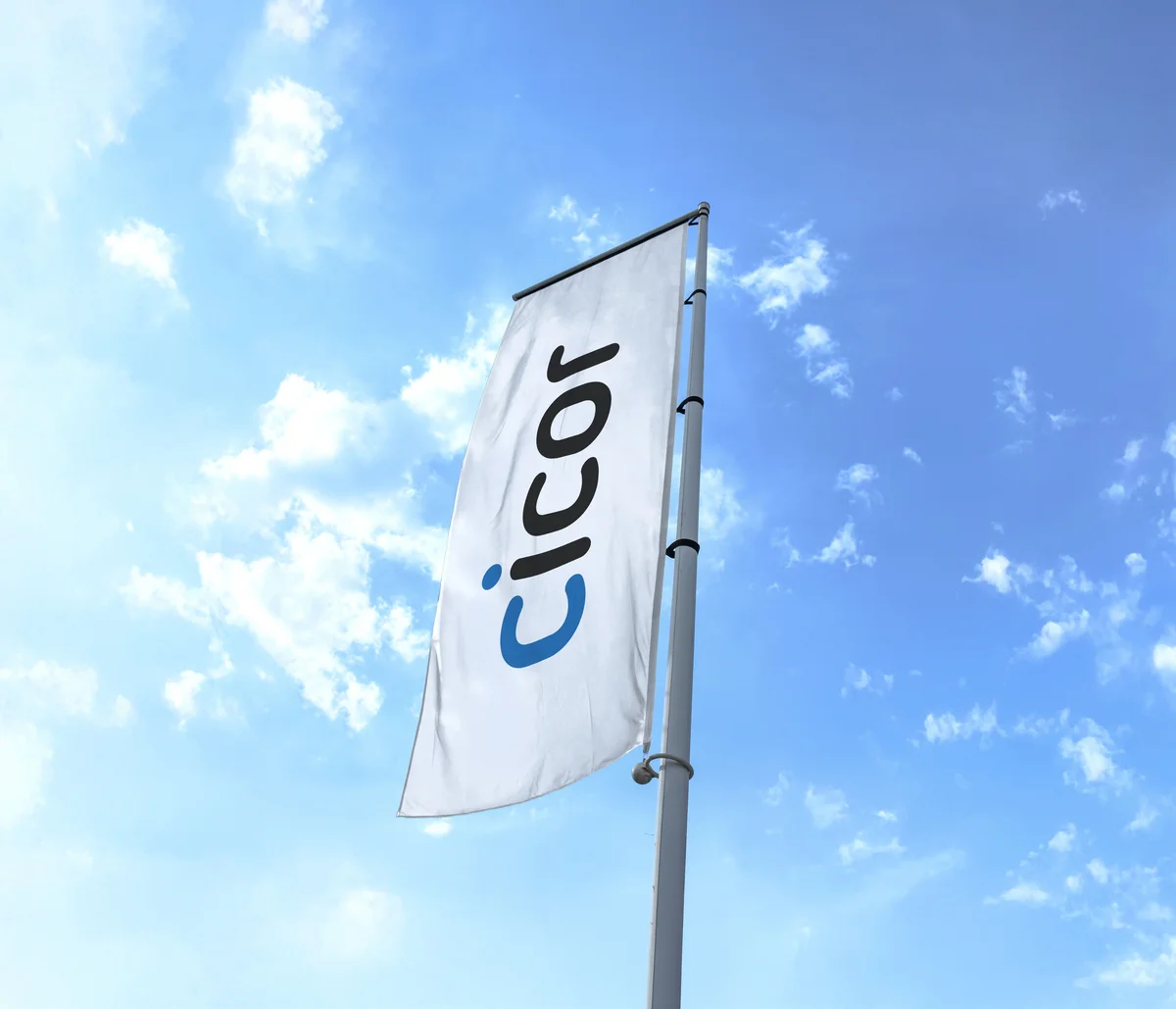 Cicor corporate flag flying against a blue sky with white clouds.