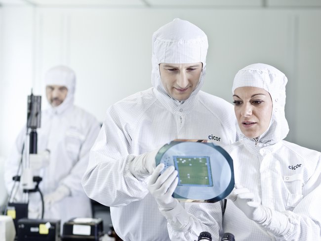 Cicor employees inspecting a thin-film substrate at the Cicor production site in Wangs, Switzerland