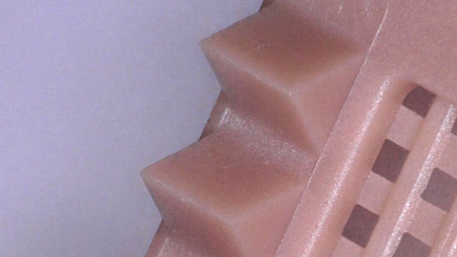 Close-up of a micro-molded plastic part demonstrating Cicor's precision plastics capabilities.