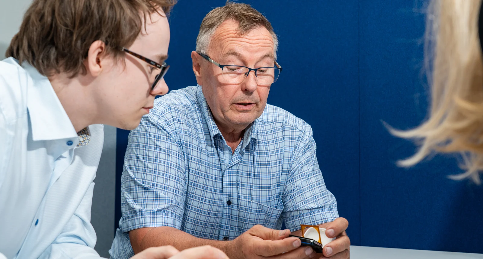 Dan Negrea and Elias Kettunen from Cicor examining a small electronic component during a technical discussion.
