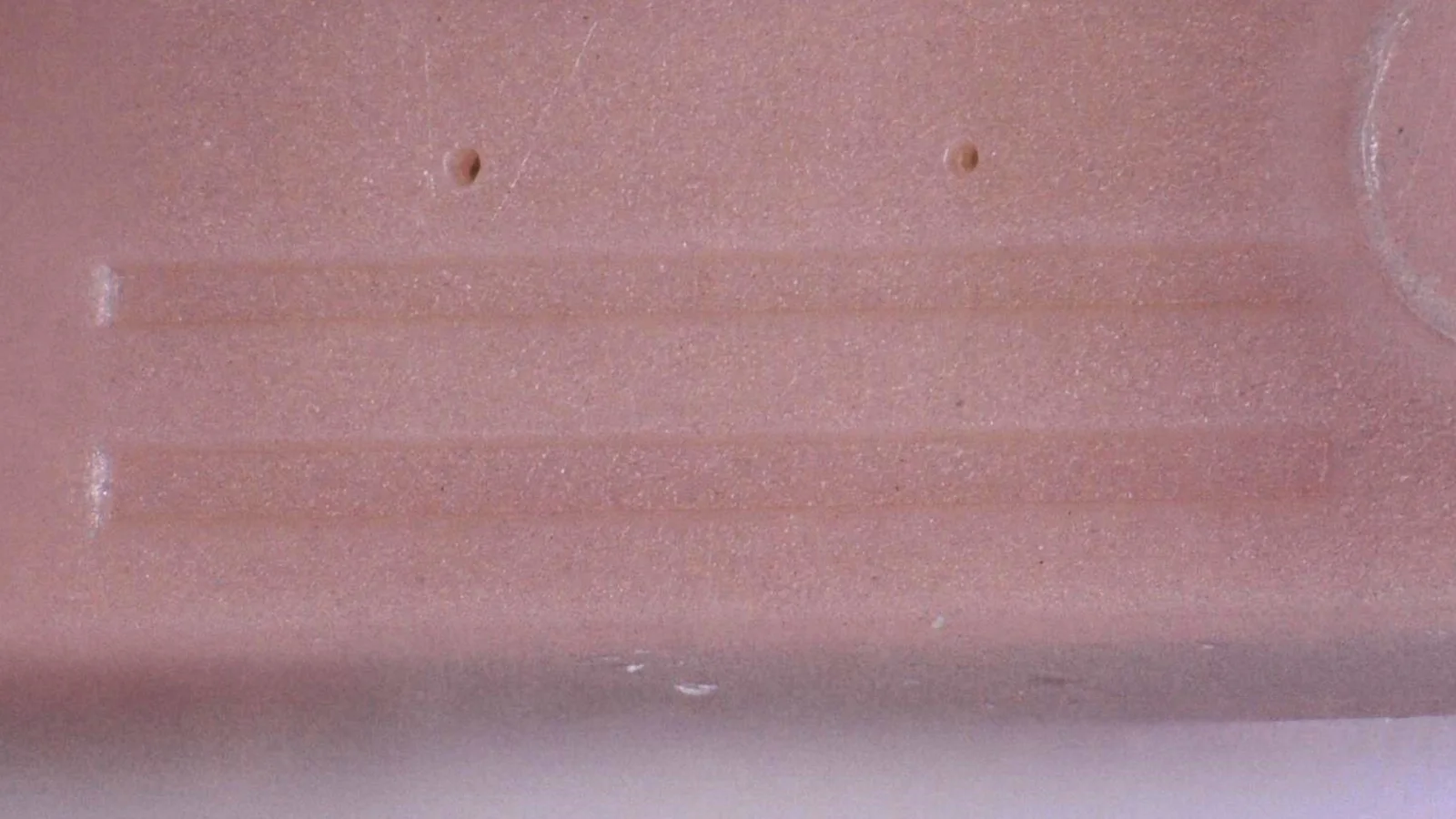 Close-up of a micro-molded plastic part demonstrating Cicor's precision plastics capabilities.