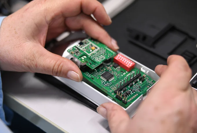 Close-up of a Cicor employee integrating a PCB into a housing (box building)