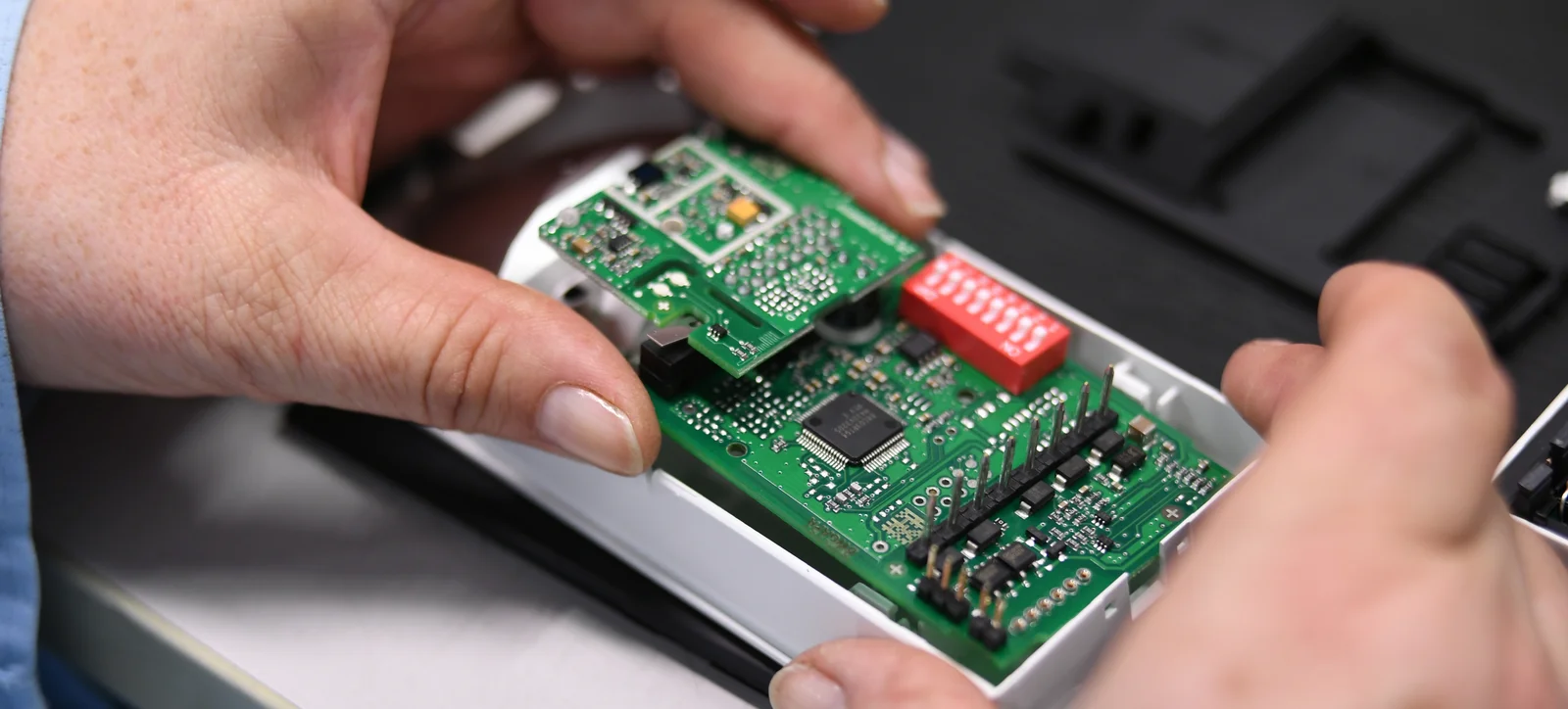 Close-up of a Cicor employee integrating a PCB into a housing (box building)