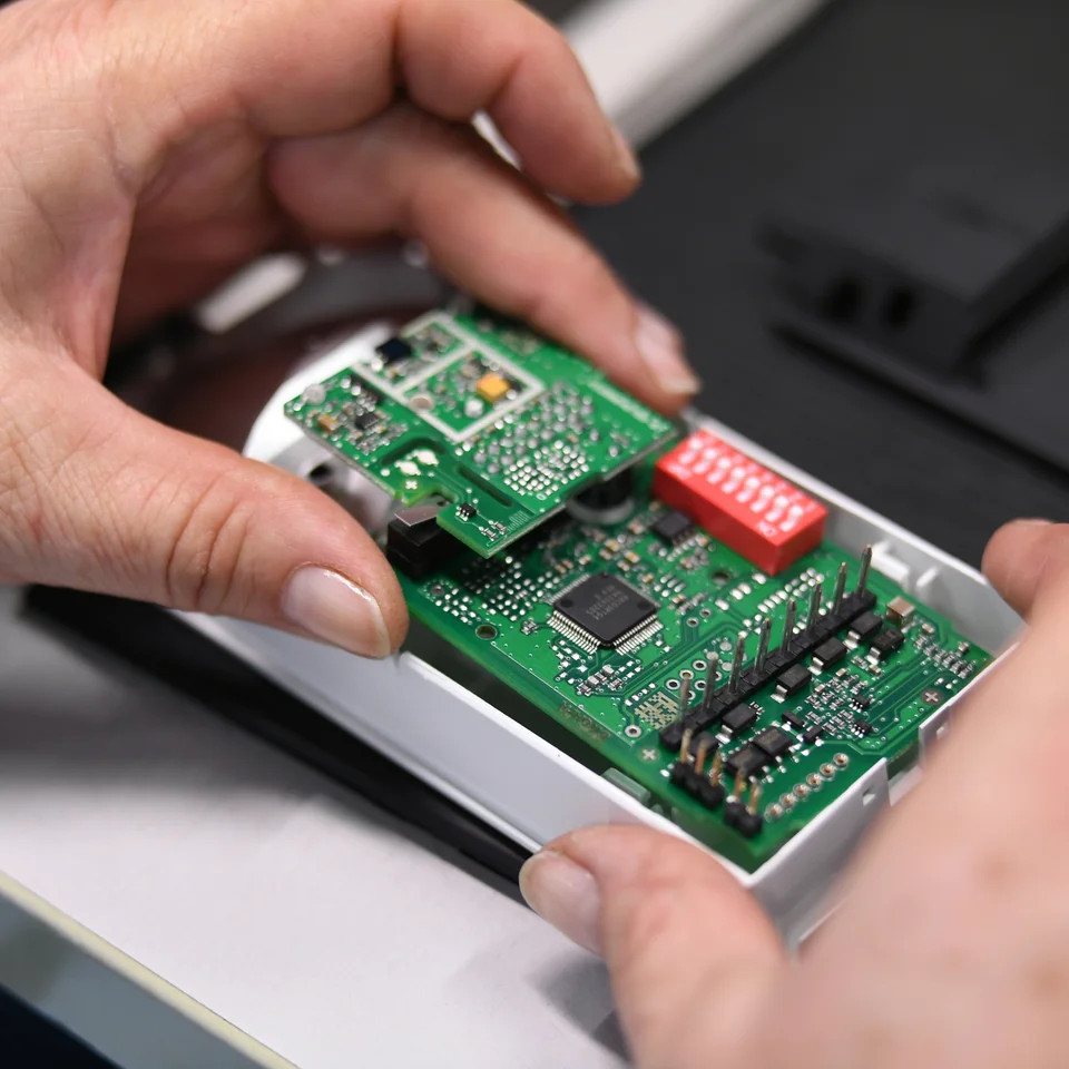 Close-up of a Cicor employee integrating a PCB into a housing (box building)