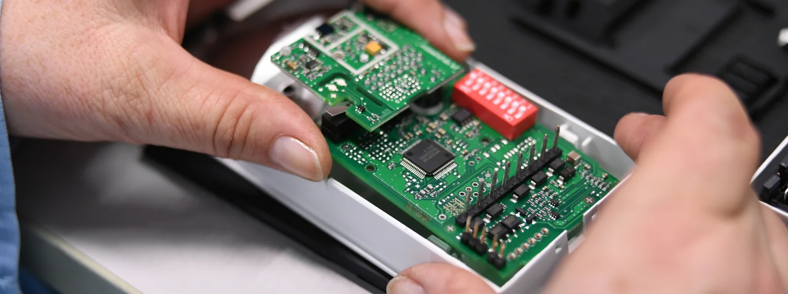 Close-up of a Cicor employee integrating a PCB into a housing (box building)