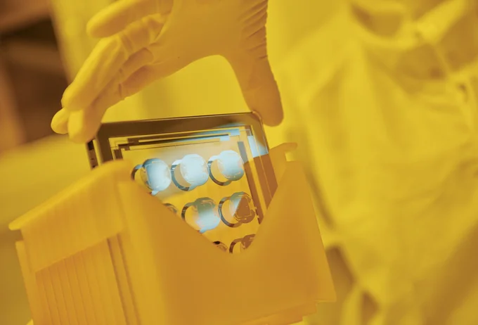 Cicor employee holding a thin-film substate at the production site in Wangs, Switzerland